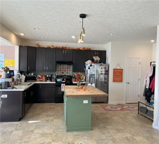 kitchen with stainless steel fridge, black range with electric cooktop, sink, pendant lighting, and a kitchen island