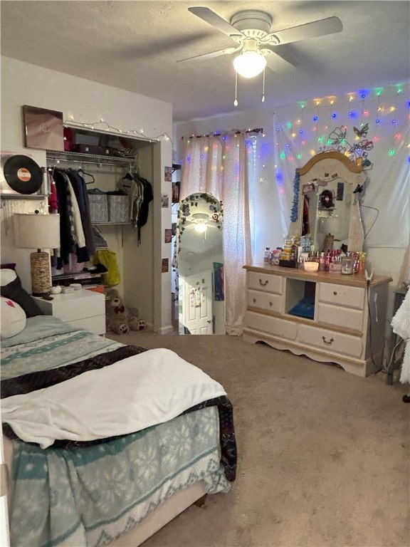 carpeted bedroom featuring ceiling fan and a closet