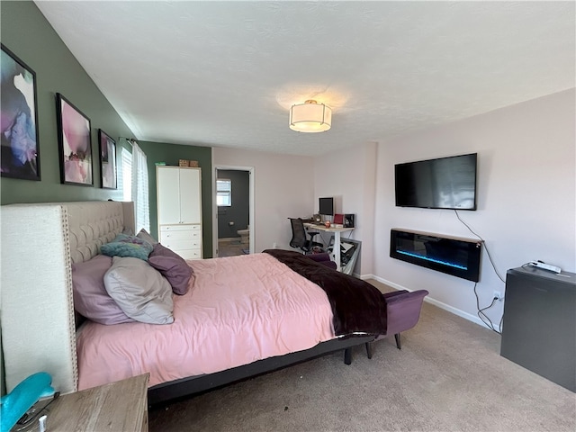 carpeted bedroom featuring ensuite bathroom and a textured ceiling