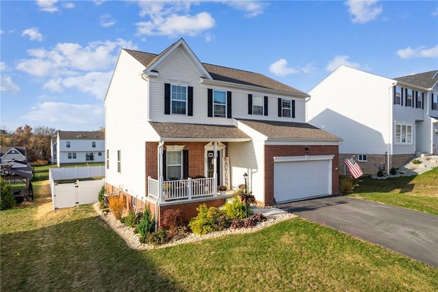 view of front of house with a porch, a garage, and a front lawn