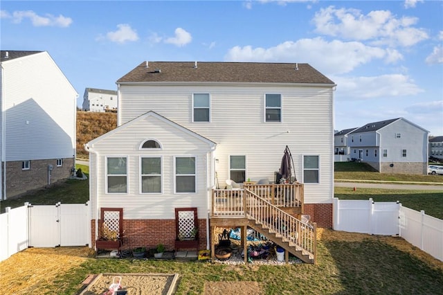 back of property with a deck and a yard