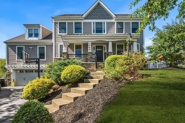 view of front of house with a front yard, a garage, and a porch