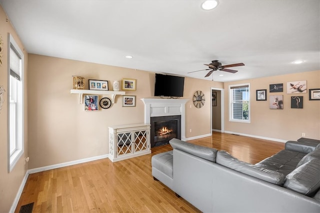 living room featuring light hardwood / wood-style floors and ceiling fan