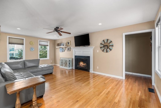 living room with light wood-type flooring and ceiling fan