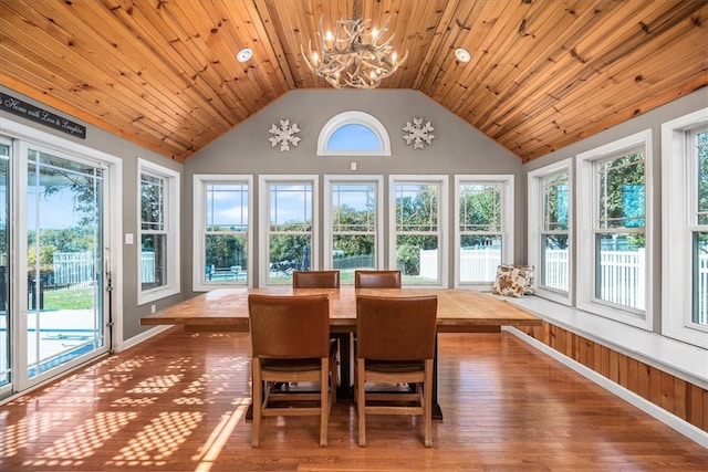 sunroom / solarium with lofted ceiling, a healthy amount of sunlight, a chandelier, and wooden ceiling