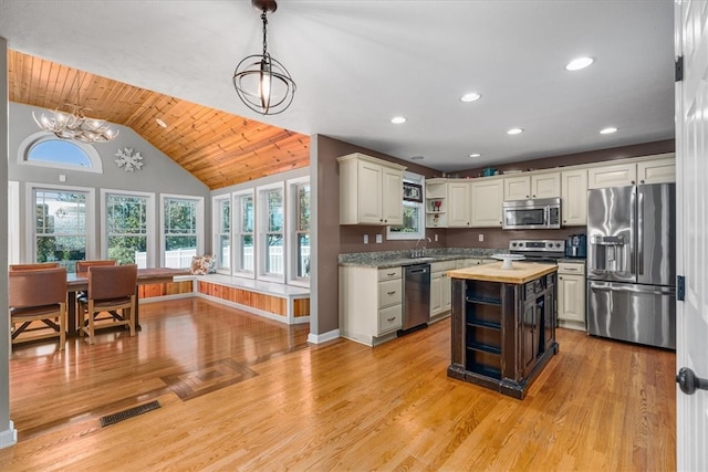 kitchen with hanging light fixtures, appliances with stainless steel finishes, light wood-type flooring, vaulted ceiling, and butcher block countertops