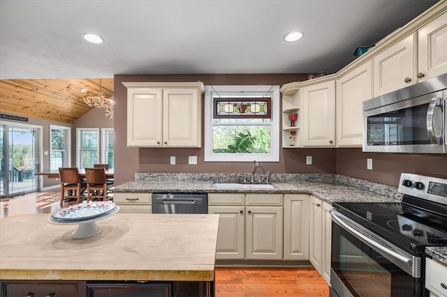 kitchen featuring lofted ceiling, wood ceiling, sink, light hardwood / wood-style floors, and stainless steel appliances