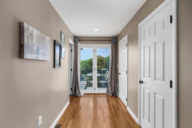 hallway featuring wood-type flooring and a textured ceiling