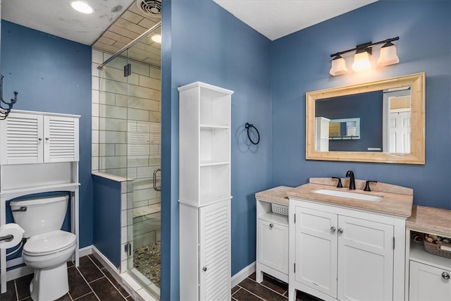 bathroom with vanity, toilet, a shower with shower door, and tile patterned flooring