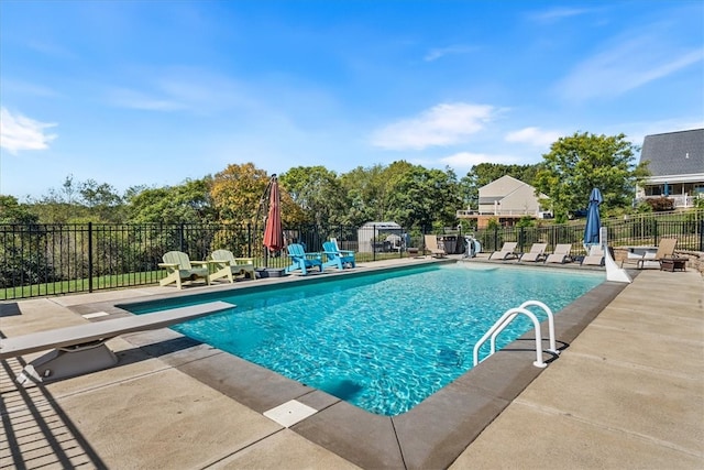 view of pool featuring a patio and a diving board