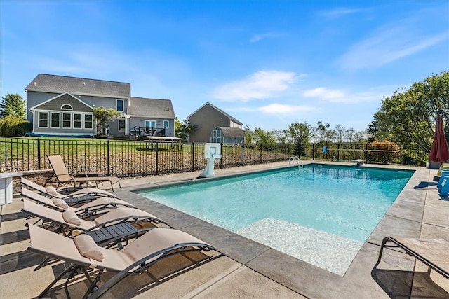 view of pool with a patio and a lawn