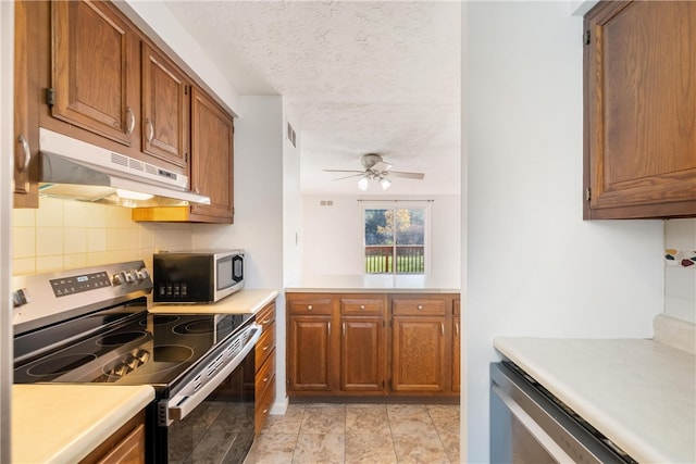 kitchen with a textured ceiling, tasteful backsplash, stainless steel appliances, and ceiling fan