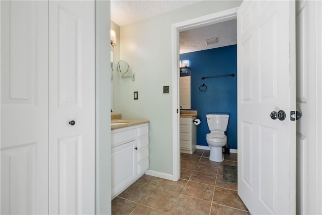 bathroom with vanity, a textured ceiling, toilet, and tile patterned floors