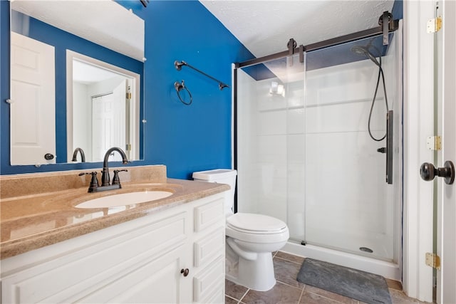 bathroom with tile patterned floors, toilet, a shower with shower door, vanity, and a textured ceiling