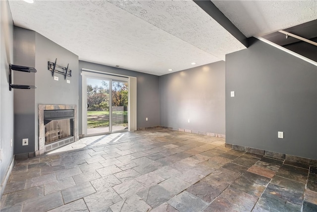 unfurnished living room with a textured ceiling and a tile fireplace