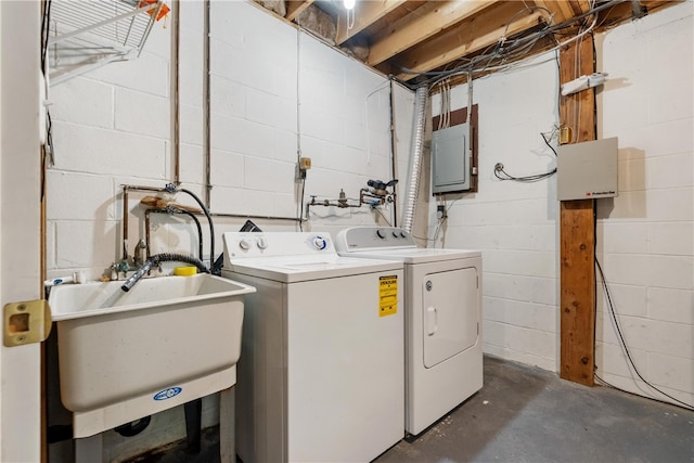 clothes washing area featuring independent washer and dryer, electric panel, and sink