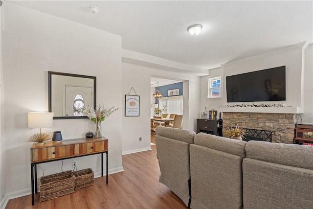 living room featuring a fireplace, wood-type flooring, and ornamental molding