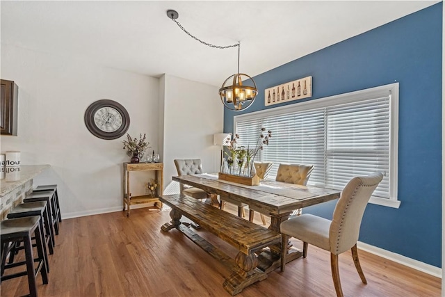 dining room with hardwood / wood-style flooring and a chandelier