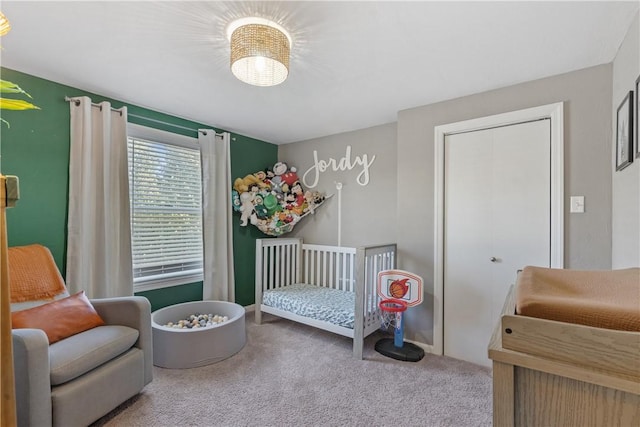 carpeted bedroom featuring a closet and a crib