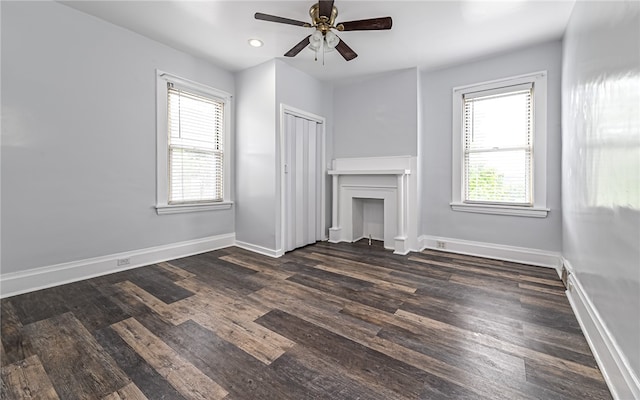 unfurnished living room with dark wood-type flooring and ceiling fan