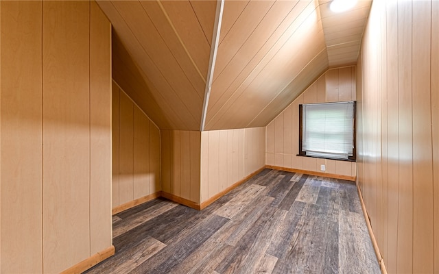 bonus room featuring lofted ceiling, wood walls, and dark hardwood / wood-style flooring