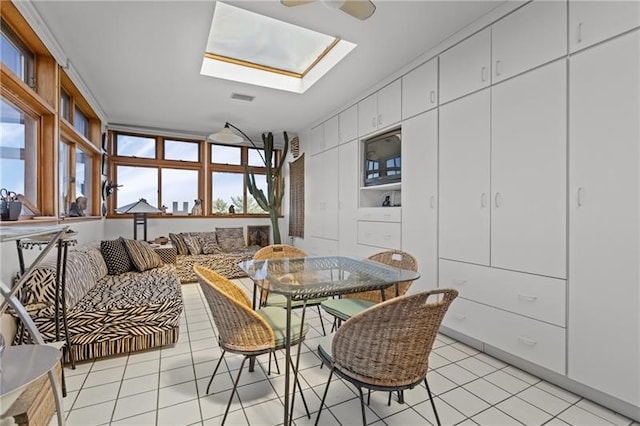 dining room featuring light tile patterned flooring, a skylight, and ceiling fan