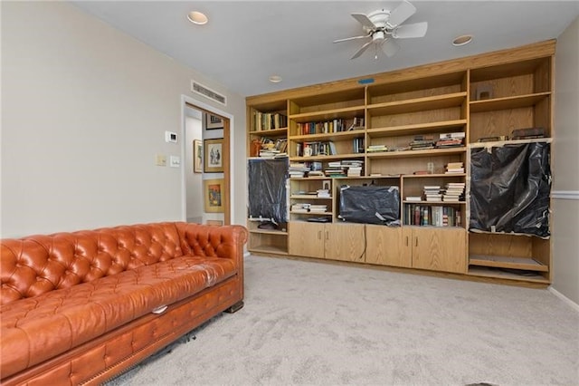 carpeted living room with ceiling fan