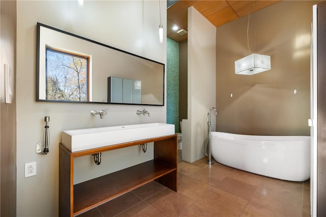 bathroom featuring vanity, tile patterned flooring, and a bathing tub