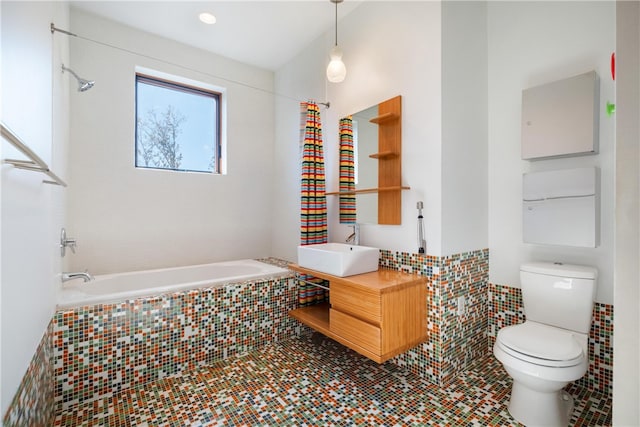 bathroom with toilet, vanity, and tiled tub