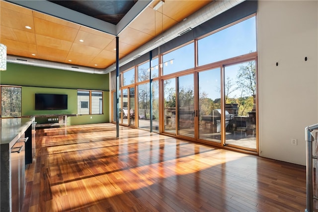 interior space with hardwood / wood-style floors and a towering ceiling