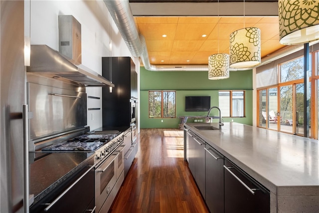 kitchen with wall chimney range hood, sink, a spacious island, dark wood-type flooring, and double oven range