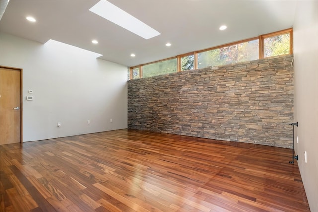 unfurnished room featuring hardwood / wood-style flooring and a skylight