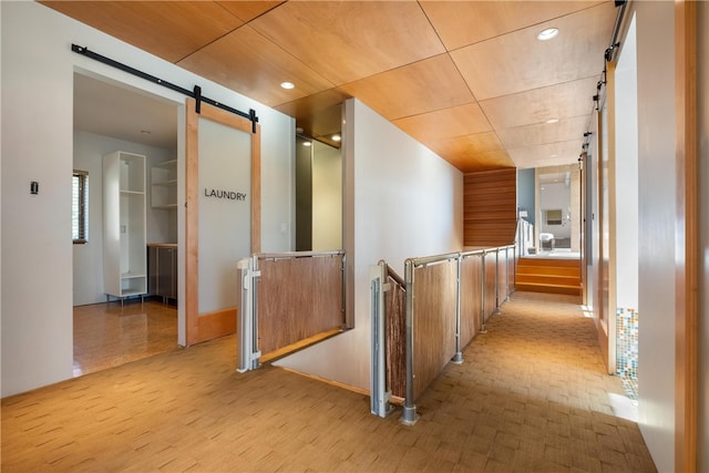 hallway with light hardwood / wood-style floors and a barn door