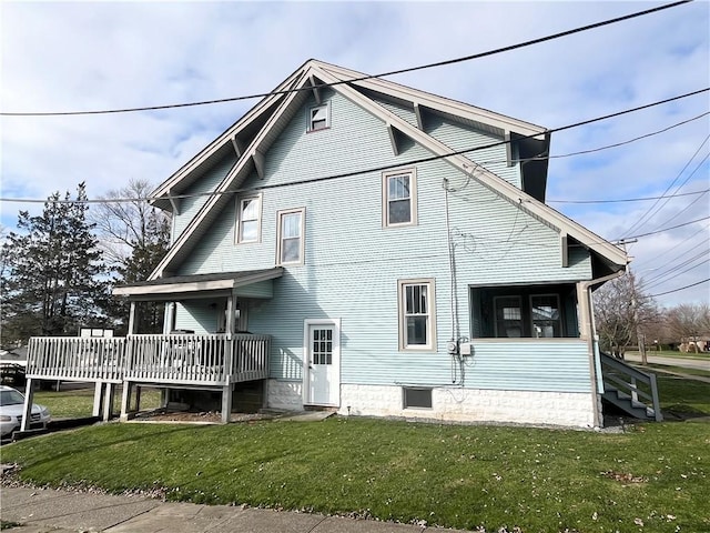 rear view of house with a yard and a wooden deck