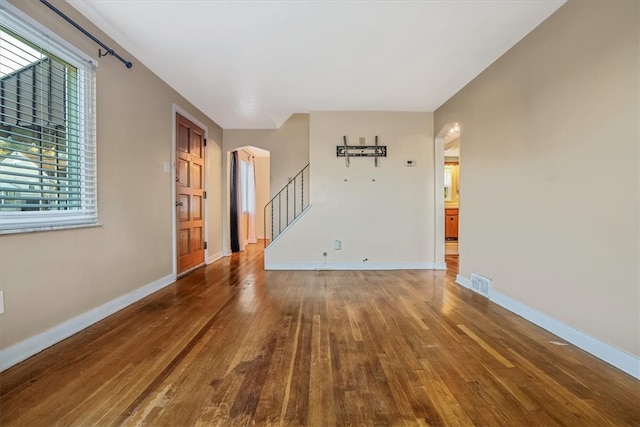 spare room with a wealth of natural light and wood-type flooring