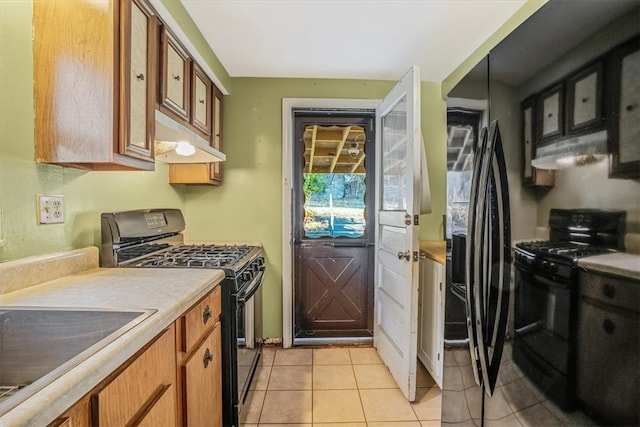 kitchen with sink, black appliances, and light tile patterned flooring