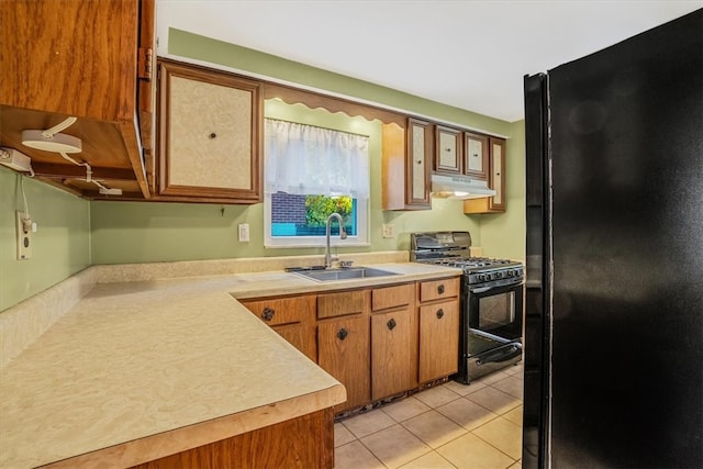 kitchen featuring light tile patterned flooring, black appliances, and sink