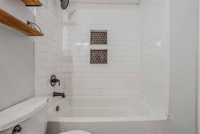 bathroom featuring toilet and tiled shower / bath