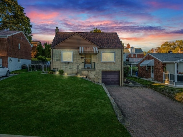 view of front of property featuring a garage and a lawn