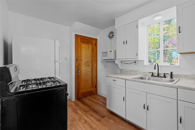 kitchen with sink, white cabinets, light wood-type flooring, and white appliances