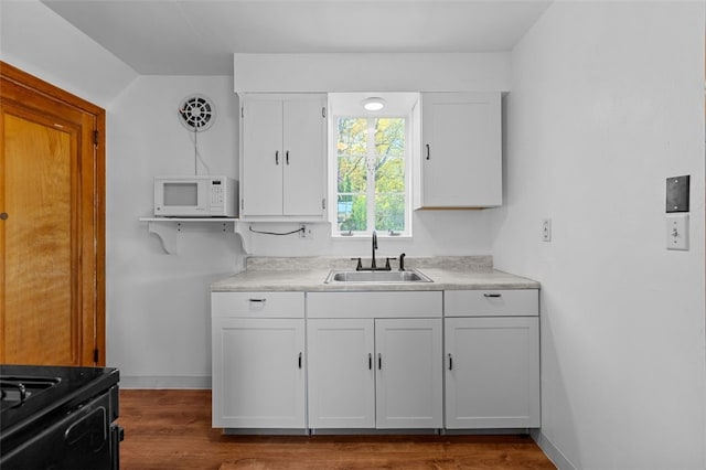 kitchen featuring black electric range oven, white cabinetry, sink, and dark hardwood / wood-style floors