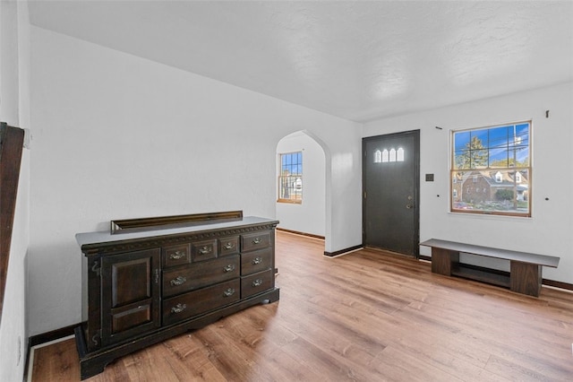 entryway with a textured ceiling and light wood-type flooring