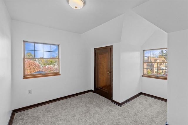 unfurnished bedroom with vaulted ceiling and light colored carpet