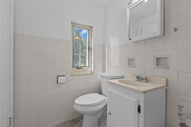 bathroom with tile walls, vanity, and toilet