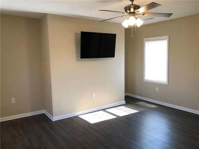 empty room with dark wood-type flooring and ceiling fan