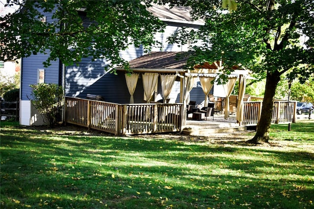 rear view of property featuring a deck, a patio area, and a lawn