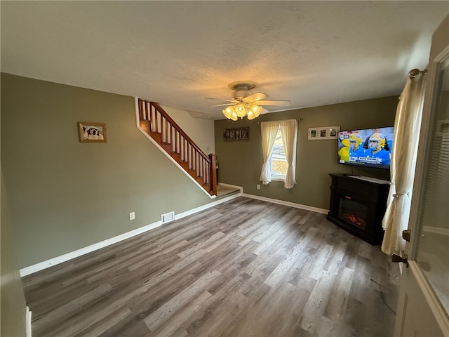 unfurnished living room featuring ceiling fan, a textured ceiling, and hardwood / wood-style flooring