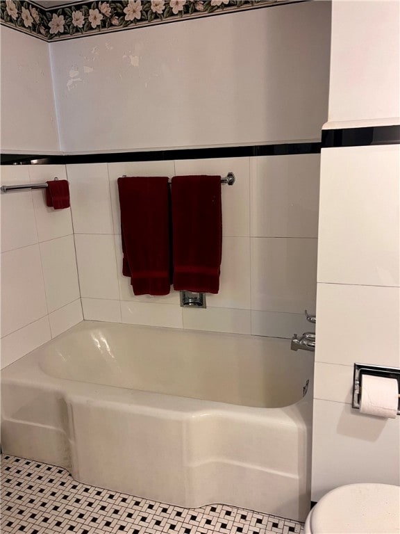 bathroom featuring tile patterned floors, a bathtub, and toilet