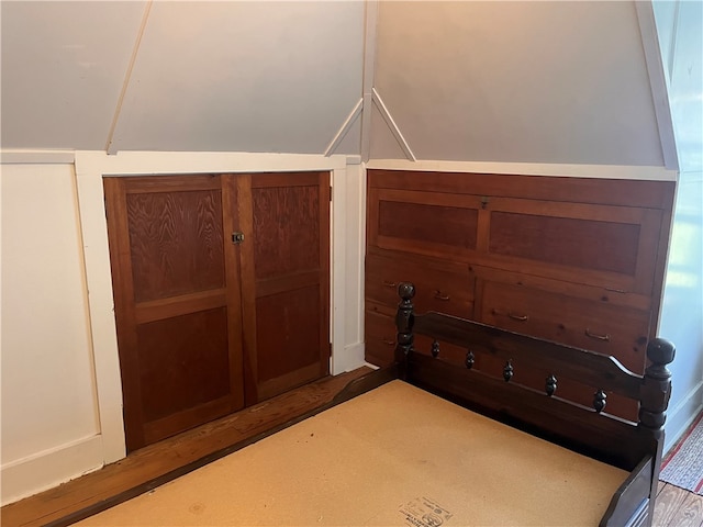 unfurnished bedroom featuring hardwood / wood-style floors and vaulted ceiling