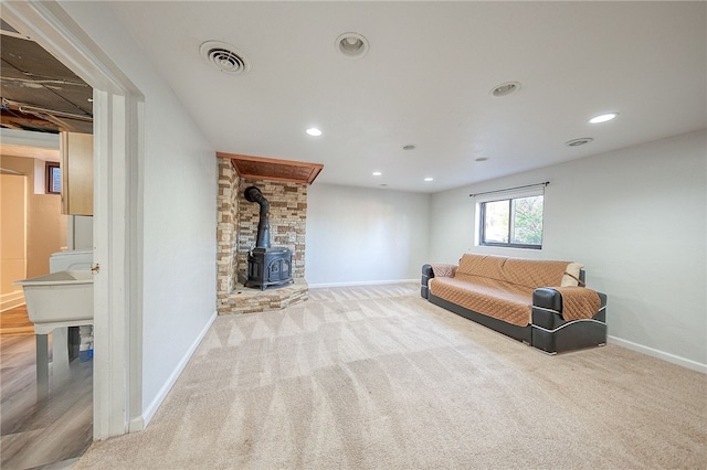 carpeted living room with a wood stove